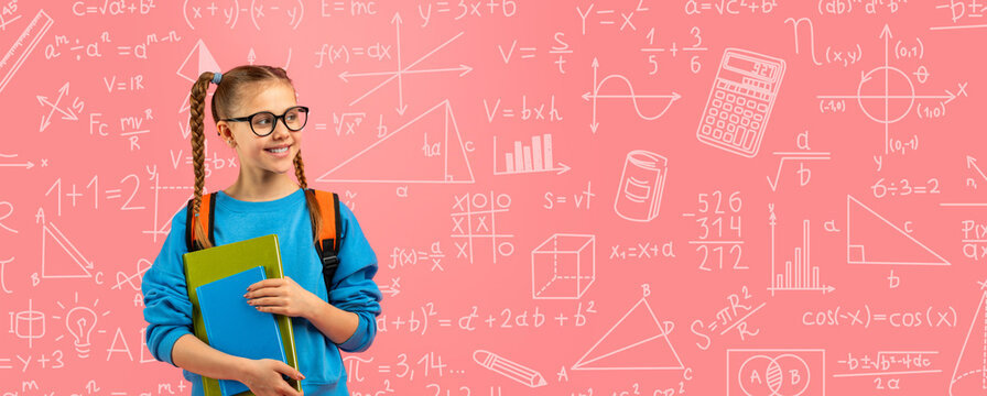 A young student with glasses stands in a classroom setting. She has pigtails and holds two books. Behind her is a pink wall covered in math drawings and formulas. It looks lively and engaging.