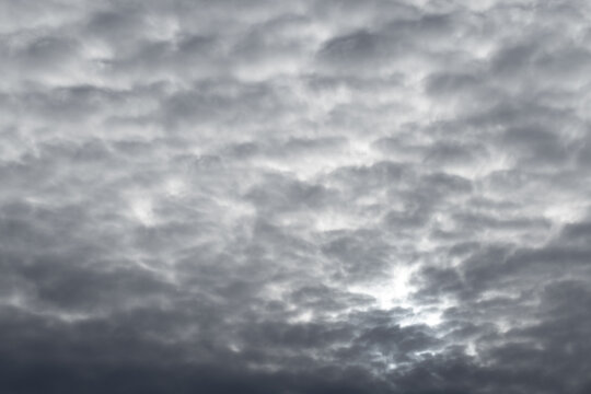 Heavy gray stratocumulus clouds fill the sky in a dramatic overcast cloudscape, creating a moody, textured backdrop with diffused light and a sense of calm before an approaching storm