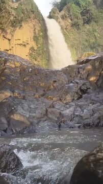 Low Angle View of Grand Waterfall with Rushing Water and Boulders