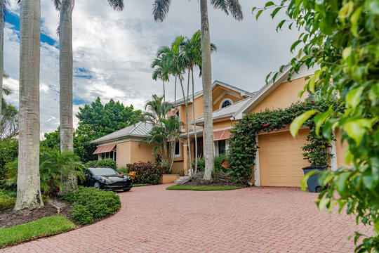 Modern residential home with tropical landscaping and palm trees in Naples Florida neighborhood