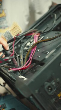 Inside a computer showing wires and components while someone works on the setup in a home workspace