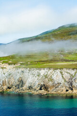 Obraz premium Misty White Cliffs of Ashleam on Achill Island, County Mayo, Ireland. Dramatic Atlantic sea cliffs and turquoise water on the Wild Atlantic Way.