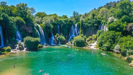 Fototapeten Wald Fluss A river flows amidst stones and dampness  perfect nature coexists, Natural waterfalls amidst green, tree-filled mountains.  © angel
