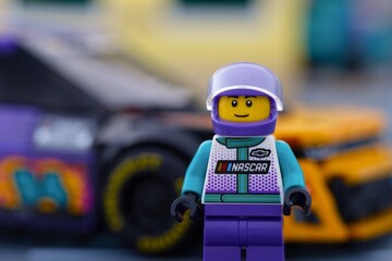Fototapeta premium Tambov, Russian Federation - January 02, 2026 Portrait of Lego NASCAR Next Gen Chevrolet Camaro ZL1 driver minifigure standing near his car. LEGO Speed Champions.