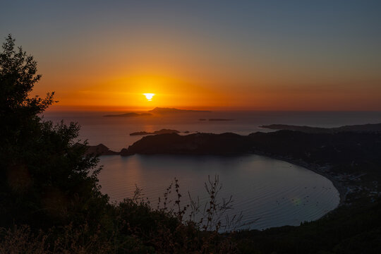 Scenic view on Akra Arilla, cape Arilla and Agios Georgios Pagon on Corfu island in the evening. Colorful sunset view over Ionian Sea and rocky cliffs.