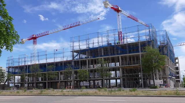 Madrid, Spain - May 12, 2026: Large residential construction site with tower cranes, scaffolding and reinforced concrete structure in Valdebebas urban development area. Editorial.