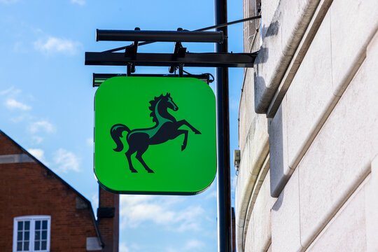 Lloyds Bank hanging signage - green with black horse - located at a branch on the high street.