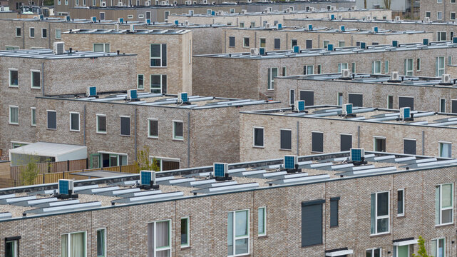 Aerial view of modern brick residential buildings with flat roofs and air conditioning units in Almere, Flevoland, Netherlands.