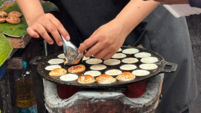 Closeup of Hands Making Thai Coconut Pancakes at a Street Market