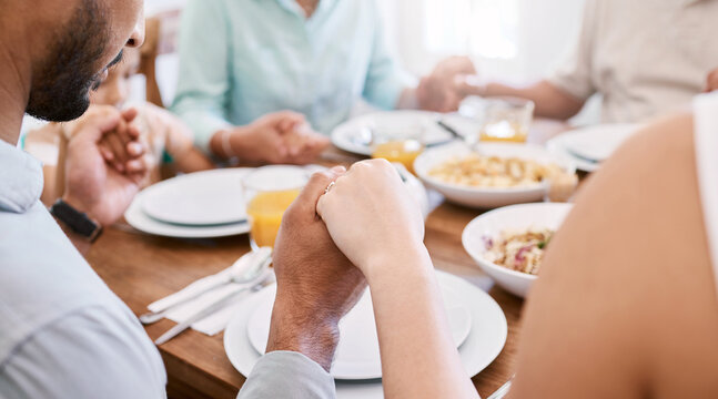 Family, praying and holding hands in home with food for lunch, religion and belief with faith together. Thankful, spiritual and people with prayer for meal, gratitude and blessing at dining table