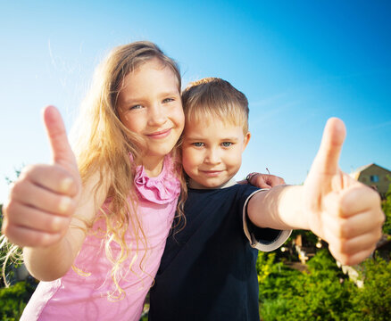 Happy smiling children at summer. Portrait of Family outdoors, kids looking at camera and they show the ok sign