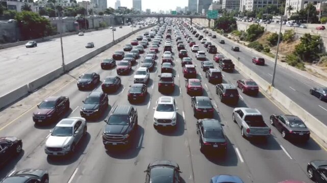 Aerial view of heavy morning commute traffic congestion on busy urban highway with multiple lanes of vehicles moving slowly through metropolitan city downtown.
