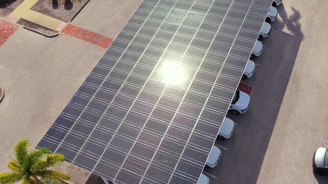 Solar canopy over car parking space generating renewable energy and providing shade for vehicles.