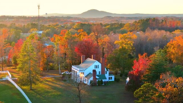 Spacious rural houses among yellow fall foliage in South Carolina suburbs. Beauty of seasonal colors in quiet countryside aria.
