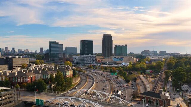 Urban Atlanta cityscape with modern skyscraper buildings and driving traffic on elevated interstate highways. American transportation system and metropolitan mobility.