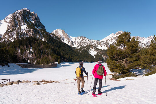 Grupo de chicos haciendo raquetas de nieve en el Parque Nacional de Aig&uuml;estortes y Estany de Sant Maurici, en los Pirineos espa&ntilde;oles. Disfrutan de una ruta de senderismo invernal entre bosques