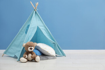 Wigwam, toy bear and pillows in child's room, space for text © New Africa