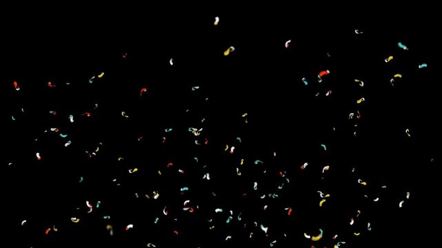 Colorful confetti falling against black background in slow motion cinematic video clip.