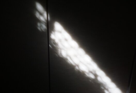 Abstraktes Motiv mit wei&szlig;em Lichtstrahl mit Muster verl&auml;uft quer &uuml;ber schwarzen Hintergrund 