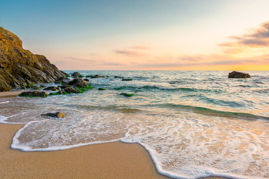 sandy beach of a black sea at sunrise. bulgaria scene on hot summer vacation season. beautiful view of waves washing the sand in morning light. generic image of seascape and sky for background