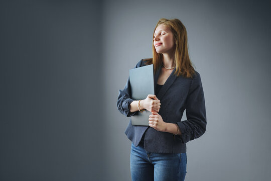  Confident young businesswoman dreams of a perfect job on isolated grey background.