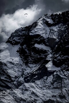 Two paragliders over snowy peak with dramatic clouds, Sellrain, Innsbruck, Tyrol, Austria