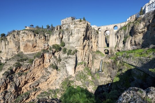 Bridge Puente Nuevo with waterfall at steep cliffs, Tajo gorge and river R&iacute;o Guadalev&iacute;n, Ronda, province of Malaga, Andalusia, Spain