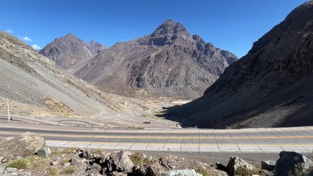 Untitled ProjectTrucks, cars, and motorbikes travel along the winding switchbacks on the Chilean side of Paso Internacional Los Libertadores (Cristo Redentor Pass), showing the serpentine mountain.