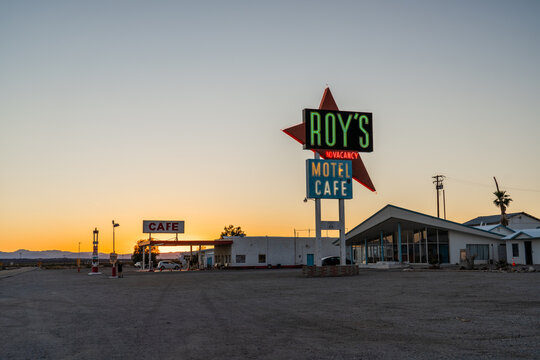 Amboy, USA - April 6th 2026: The legendary Roy's Motel and Caf&eacute; neon sign stands tall against a golden sunset in Amboy, California, capturing the timeless essence of historic Route 66