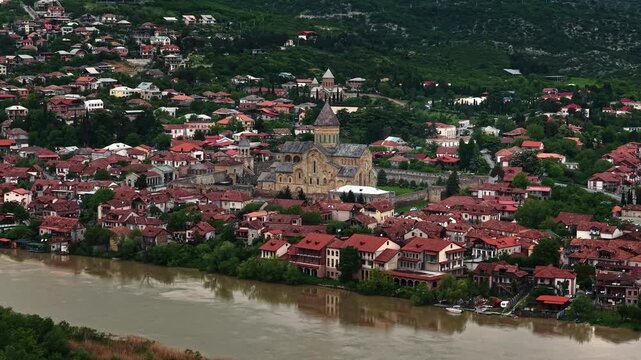 Cinematic aerial drone footage of the historic Svetitskhoveli Cathedral located in Mtskheta. One of the most important Orthodox landmarks in Georgia, surrounded by scenic landscapes 