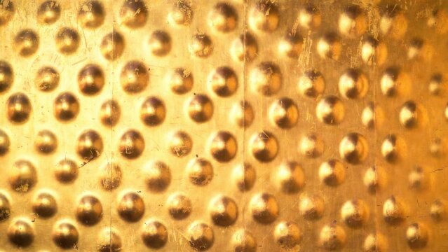 Gold metallic surface with raised circular studs closeup