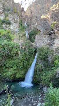 Powerful white waters of Catarata Corbata Blanca cascading through steep rocky cliffs in  Patagonia, Argentina. Scenic view of one of the tallest waterfalls near El Bols&oacute;n.