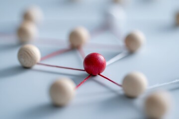 Obraz premium A red wooden sphere as a central hub in a network of connections. Concept of leadership, teamwork, and standing out from the crowd