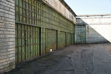 Fototapeta premium Weathered Green Metal Hangar Doors at Abandoned Industrial Site