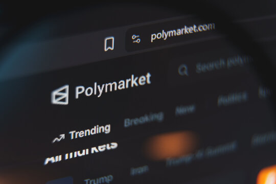 Polymarket website interface viewed through magnifying glass, decentralized prediction market platform for betting on politics, crypto, and global events concept