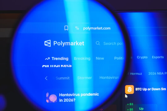 Polymarket website interface viewed through magnifying glass, decentralized prediction market platform for betting on politics, crypto, and global events concept
