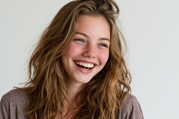 Fototapeta premium Joyful young woman with radiant smile and tousled hair