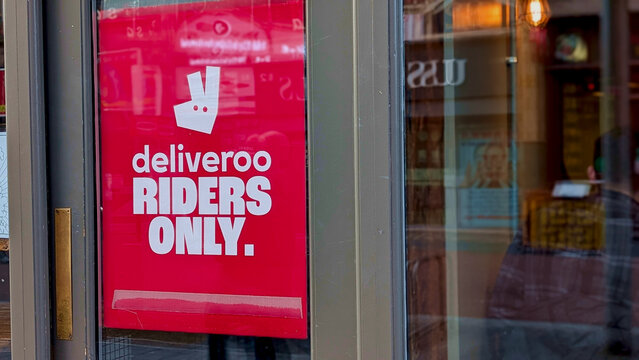 Leicester, England, UK - 14 February 2026: Deliveroo riders only sign on restaurant door, food delivery service concept, takeaway logistics, courier pickup point, red informational poster, street phot
