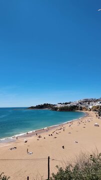 Video of the popular tourist activity at Praia do Camilo in Lagos, Portugal, where several boat tours gather together while visitors paddle through the stunning coastal waters in kayaks and canoes