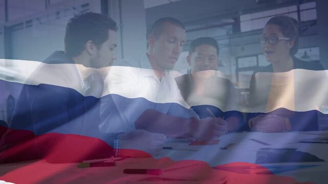 Business team of 4 reviewing charts central man reaching and signing flag overlay rippling smiling