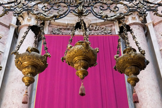 Ornate brass hanging lamps with vivid magenta backdrop