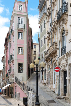 Narrow old town street with pastel buildings and ornate facade