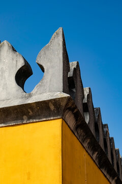 Yellow architectural parapet against a blue sky