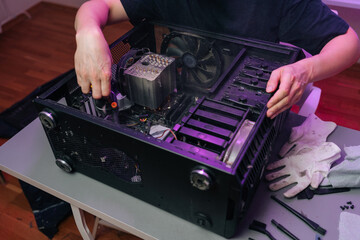Person hands removing components from an open desktop computer case on desk, performing maintenance...
