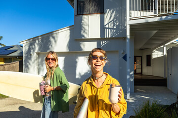 Happy women holding surfboards walking in australia © unai