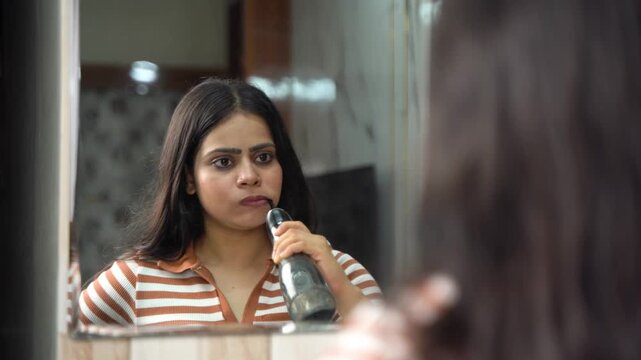 Indian Woman Using Water Flosser for Oral Care and Dental Hygiene at Home