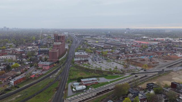 Aerial perspective revealing Gardiner Expressway and railways in Toronto, Ontario, showcasing urban development, busy vehicle traffic, city infrastructure