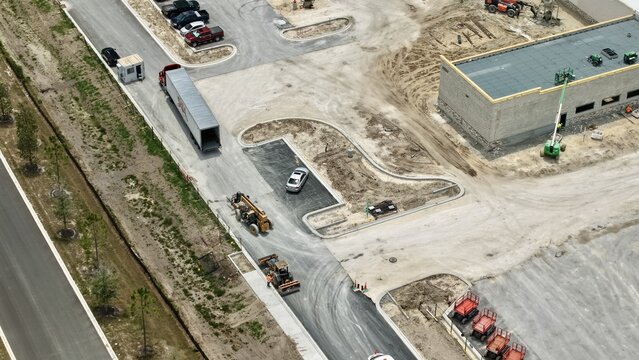 Aerial view of the construction site at Foundry Lane featuring heavy machinery, a semi-truck, and a building under development in World Golf Village, Florida, United States.