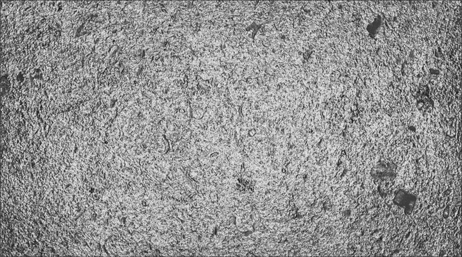 A close-up shot of a textured, mottled surface, with specks throughout. The texture is irregular, with a slightly rough feel. 