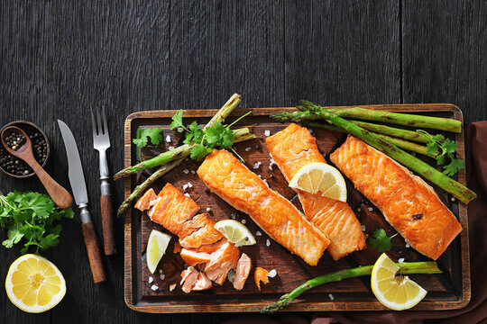 fried salmon with asparagus and lemon on a board